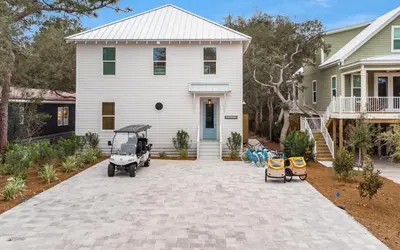 a golf cart parked in front of a house at Sand Juan by Oversee 30A in Santa Rosa Beach