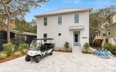a golf cart parked in front of a house at Sand Juan by Oversee 30A in Santa Rosa Beach