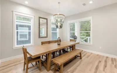 a dining room with a table and chairs and windows at Sand Juan by Oversee 30A in Santa Rosa Beach