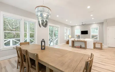 a dining room with a large wooden table and chairs at Sand Juan by Oversee 30A in Santa Rosa Beach