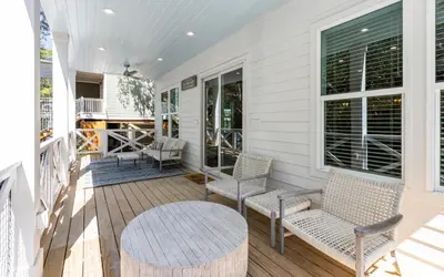 a porch with chairs and a table on a house at Sand Juan by Oversee 30A in Santa Rosa Beach