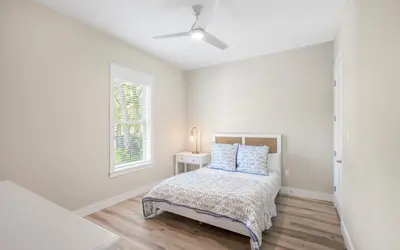a white bedroom with a bed and a window at Sand Juan by Oversee 30A in Santa Rosa Beach