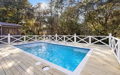 a swimming pool on a wooden deck with a fence at Sand Juan by Oversee 30A in Santa Rosa Beach