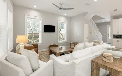 a living room with white furniture and a tv at Sand Juan by Oversee 30A in Santa Rosa Beach