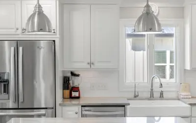a kitchen with white cabinets and a stainless steel refrigerator at Santa Rosa Seaclusion by Oversee 30A in Santa Rosa Beach