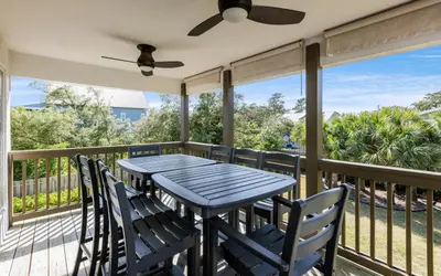 a porch with a table and chairs and a ceiling fan at Santa Rosa Seaclusion by Oversee 30A in Santa Rosa Beach