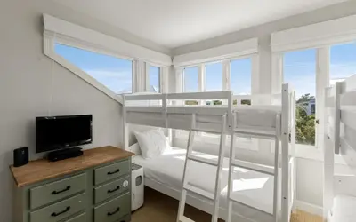 a bedroom with two bunk beds and a tv at Santa Rosa Seaclusion by Oversee 30A in Santa Rosa Beach