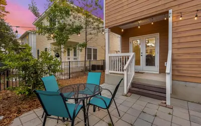 a patio with a table and chairs in front of a house at Sea Bliss Cottage by Oversee 30A in Inlet Beach
