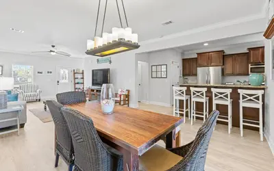 a kitchen and dining room with a wooden table and chairs at Sea Bliss Cottage by Oversee 30A in Inlet Beach