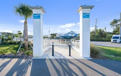 a white arch with a palm tree on a street at Sea Bliss Cottage by Oversee 30A in Inlet Beach