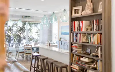 a kitchen and dining room with a bar and bookshelves at SeaGroovInn by Oversee 30A in Santa Rosa Beach