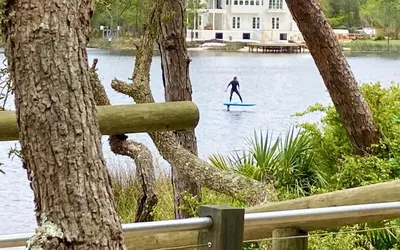a person on a paddle board in the water at SeaGroovInn by Oversee 30A in Santa Rosa Beach