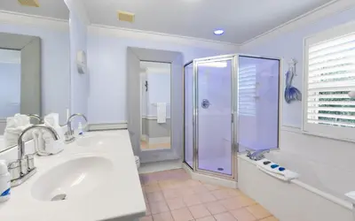 a bathroom with a shower and a tub and a sink at SeaGroovInn by Oversee 30A in Santa Rosa Beach