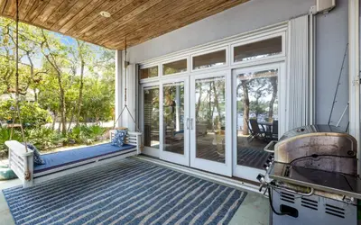 a screened porch with sliding glass doors and a grill at SeaGroovInn by Oversee 30A in Santa Rosa Beach