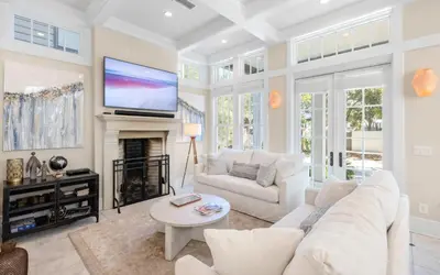a living room with a white couch and a tv at Serenity by Oversee 30A in Rosemary Beach