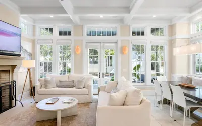 a living room with white furniture and a tv at Serenity by Oversee 30A in Rosemary Beach