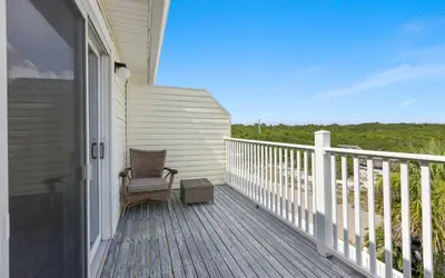 a rocking chair on the porch of a house at Shoreline 9 Unit 5 by Oversee 30A in Inlet Beach