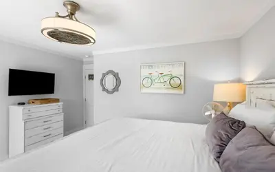 a white bedroom with a bed and a tv at Shoreline 9 Unit 5 by Oversee 30A in Inlet Beach