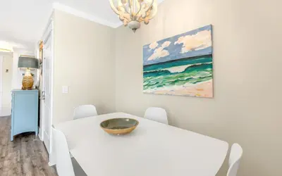a white dining room with a white table and chairs at Shoreline 9 Unit 5 by Oversee 30A in Inlet Beach