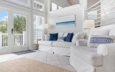 a living room with white furniture and a large window at Shores Fun by Oversee 30A in Seacrest