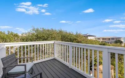 a balcony with a chair and a table and chairs at Shores Fun by Oversee 30A in Seacrest