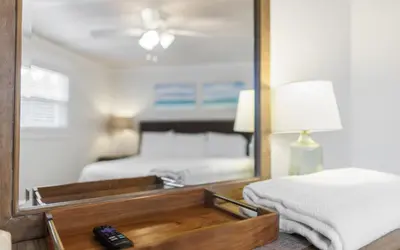 a mirror in a bedroom with a bed and a remote control at Shores Fun by Oversee 30A in Seacrest