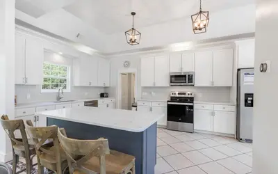 a kitchen with white cabinets and a white counter top at Shores Fun by Oversee 30A in Seacrest