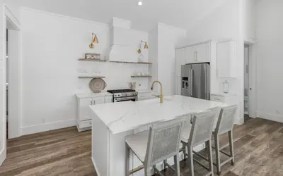 a kitchen with white cabinets and a large white island at Slim Shady by Oversee 30A in Santa Rosa Beach