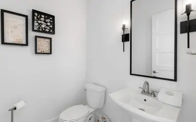 a white bathroom with a toilet and a sink at Slim Shady by Oversee 30A in Santa Rosa Beach