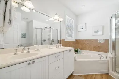 a white bathroom with a tub and a sink and a bath tubermott at Sound Waves Getaways by Oversee 30A in Rosemary Beach