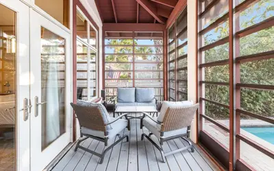 a screened porch with a table and chairs and a pool at Special Purpose by Oversee 30A in Santa Rosa Beach
