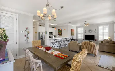 a dining room and living room with a table and chairs at Splish Splash by Oversee 30A in Seacrest