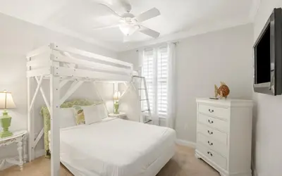 a bedroom with a white bed and a ceiling fan at Splish Splash by Oversee 30A in Seacrest