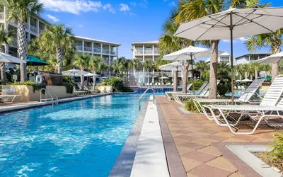 a swimming pool with chairs and umbrellas at a resort at Splish Splash by Oversee 30A in Seacrest