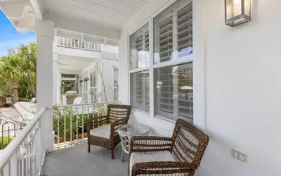 a porch with wicker chairs and a table at Splish Splash by Oversee 30A in Seacrest