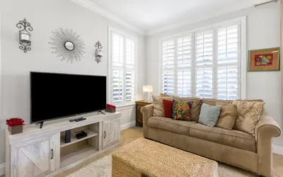 a living room with a couch and a flat screen tv at Splish Splash by Oversee 30A in Seacrest