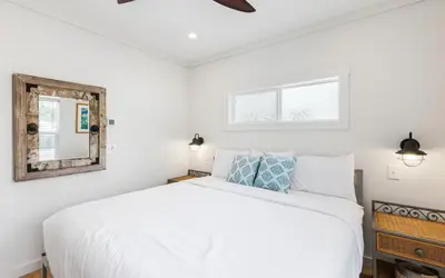 a bedroom with a white bed and a mirror at Sun Palace by Oversee 30A in Santa Rosa Beach