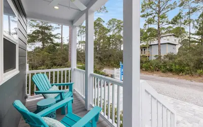 a porch with two blue chairs on it at Sun Palace by Oversee 30A in Santa Rosa Beach
