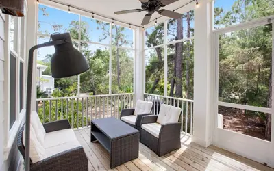 a screened porch with two chairs and a lamp at Sunseeker by Oversee 30A in Santa Rosa Beach