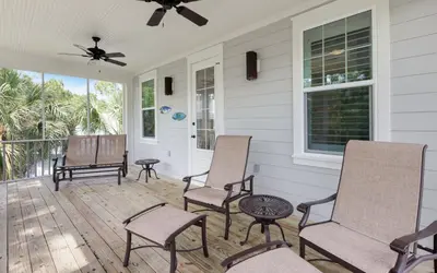 a porch with chairs and a ceiling fan at Sunseeker by Oversee 30A in Santa Rosa Beach