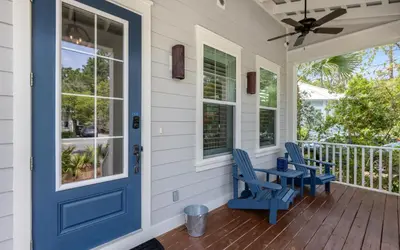 a porch with blue chairs and a blue door at Sunseeker by Oversee 30A in Santa Rosa Beach