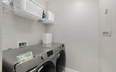 a washing machine in a laundry room with a shelf at Sunset Beach Villa A101 by Oversee 30A in Rosemary Beach