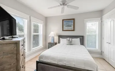 a bedroom with a bed and a flat screen tv at Sunset Beach Villa A101 by Oversee 30A in Rosemary Beach