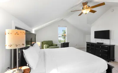 a bedroom with a white bed and a ceiling fan at The Fab Crab by Oversee 30A in Seacrest