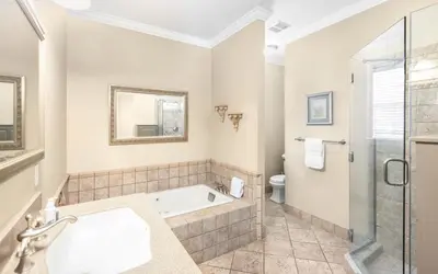 a bathroom with a bath tub and a toilet at The Fab Crab by Oversee 30A in Seacrest