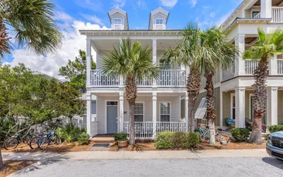 a white house with palm trees in front of it at The Fab Crab by Oversee 30A in Seacrest