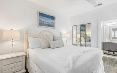 a white bedroom with a white bed and a mirror at The Palms by Oversee 30A in Santa Rosa Beach