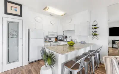 a kitchen with white cabinets and a large island at The Palms by Oversee 30A in Santa Rosa Beach