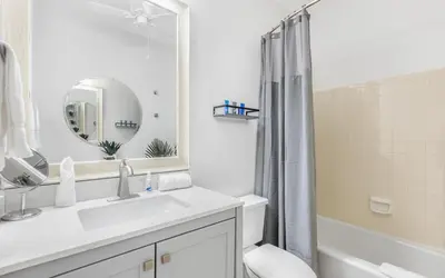 a white bathroom with a sink and a mirror at The Palms by Oversee 30A in Santa Rosa Beach