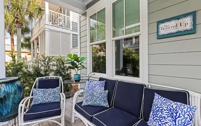 a porch with blue and white pillows and chairs at The Round Up by Oversee 30A in Inlet Beach